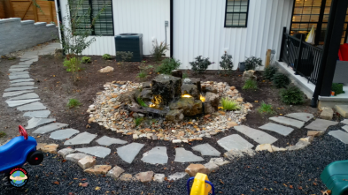 Backyard stone path with small waterfall feature.