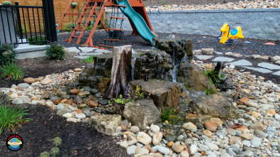 Garden waterfall next to playground and rocks