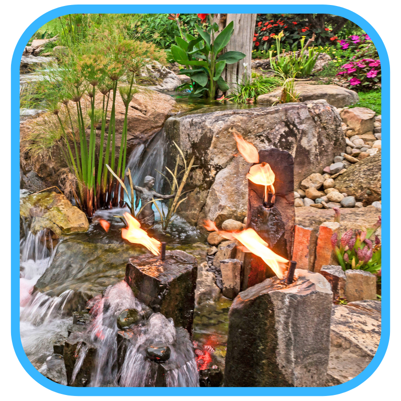 Multi-tiered fountain with waterfalls, lighting, and lush landscaping showing enhanced installation