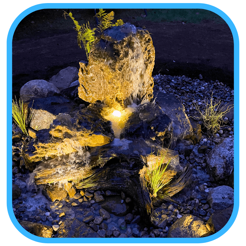 Illuminated fountain at night with dramatic lighting and water reflections