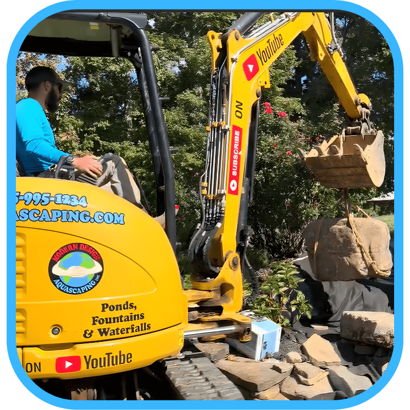 Mini-excavator working with rocks during pond construction